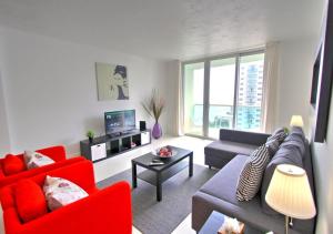 ein Wohnzimmer mit einem Sofa und roten Stühlen in der Unterkunft The Tides on Miami Hollywood Ocean View Apartments 1B in Hollywood