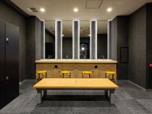 a table with four yellow chairs in a room at Akabane Holic Hotel in Tokyo