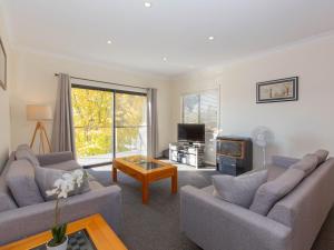 a living room with two couches and a tv at Alaska 2 8 Poley Cow Lane in Jindabyne