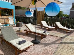 a group of chairs and an umbrella in a yard at Poko poko resort in Kralendijk