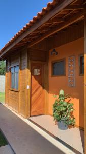 een klein huis met een plant ervoor bij Pousada Portal da Praia in Anchieta