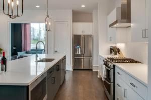 uma cozinha com armários brancos e um frigorífico de aço inoxidável em 4 Connecting Condos - Sleeps 32 to 36 - Firepits - Garages - Rooftops decks - Great Views - Security em Nashville