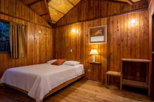 a bedroom with a bed and a television in it at Mindo Lago Hotel Destino in Mindo