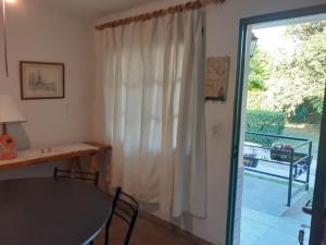a dining room with a table and a sliding glass door at SOL Y LUNA in Huerta Grande +6 photos