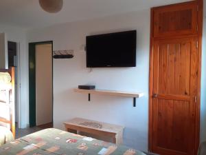 a bedroom with a television on a wall with a bed at SOL Y LUNA in Huerta Grande