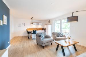 uma sala de estar com uma mesa e cadeiras e um piano em Strandvilla Meeresblick Wohnung 02 em Boltenhagen