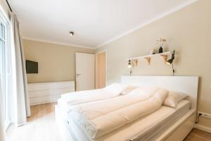 um quarto branco com uma grande cama branca em Strandvilla Meeresblick Wohnung 02 em Boltenhagen