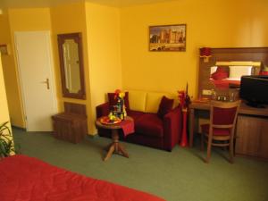 a living room with a red couch and a table at Hotel am Hauptbahnhof in Schwerin