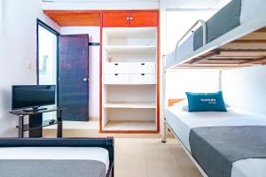 1 dormitorio con 2 camas y 1 dormitorio con litera y escalera. en Ayenda Casa Amarilla, en Santa Marta