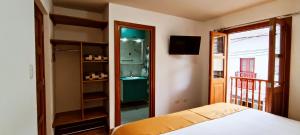 a bedroom with a bed and a bathroom with a sink at 7th Wonder Apart Hotel Cusco in Cusco