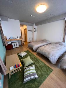 a bedroom with two beds and a green rug at Upper Hotel Ishihara in Tokyo