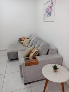 ein Wohnzimmer mit einem Sofa und einem Tisch in der Unterkunft Flat com boa localização in Palmas