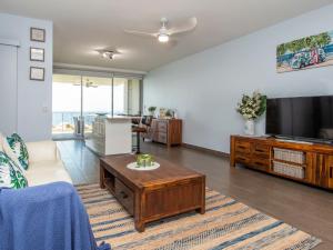 ein Wohnzimmer mit einem Sofa und einem TV in der Unterkunft 1 Bright Point Apartment 4105 in Nelly Bay