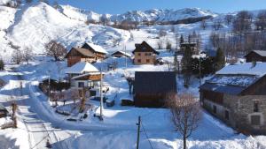 un pueblo cubierto de nieve con montañas en el fondo en Authentique grange savoyarde, en Albiez-Montrond