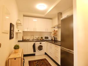 a kitchen with white cabinets and a washer and dryer at Top Floor (Atico) Apartment Close to Beach in Torre de Benagalbón