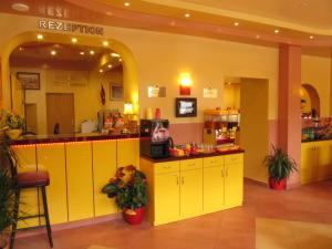 a restaurant with yellow cabinets and a counter at Hotel am Hauptbahnhof in Schwerin