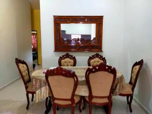 a dining room table with chairs and a mirror at Homestay Sri Uda A in Alor Setar