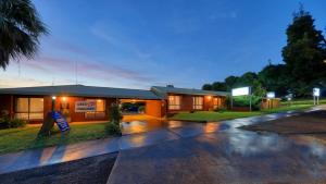 un edificio con una señal delante de él en Country Roads Motor Inn, en Narrandera