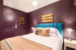 1 dormitorio con paredes moradas y 1 cama con cabecero azul en ✶ Maras Residence ✶ LUXURY Rooftop Pool & Grill, en Lima