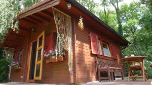 a small wooden house with flowers in the window at Ferienhaus Natura in Neuruppin