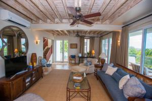 a living room with a blue couch and a ceiling fan at Marks Reef in Lance aux Épines