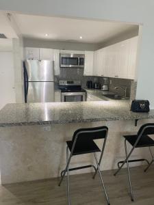 a kitchen with two chairs and a counter with a refrigerator at Large 1 Bedroom apartment at Roney Palace Sleep 8 in Miami Beach