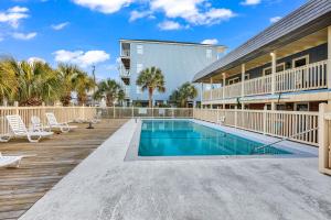 a swimming pool with chairs and a building at Cherry Grove 26 in Myrtle Beach