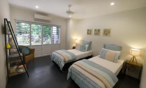 Un dormitorio con dos camas y una ventana. en Sienna-Rose, en Mission Beach 18 fotos más