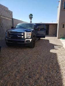 a blue truck parked in a gravel parking lot at Brothers Townhouse Puerto Peñasco, Centro in Puerto Peñasco