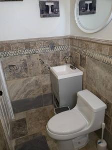 a bathroom with a toilet and a sink and a mirror at Brothers Townhouse Puerto Peñasco, Centro in Puerto Peñasco
