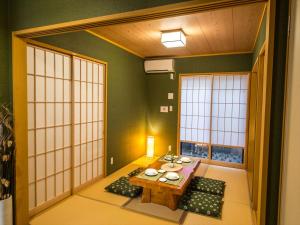 een eetkamer met een tafel en een kamer met ramen bij YADOYA 烏丸院 in Tokyo