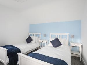 a bedroom with two beds and two night stands at Awel Deg Parc Delfryn in Brynteg