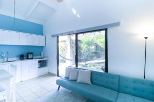 a living room with a blue couch and a large window at Villaggio Claudia 29B in Potrero