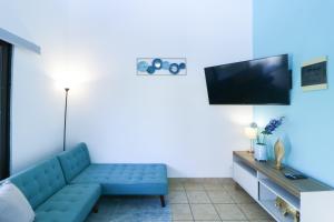 Una sala de estar con un sofá azul y un televisor de pantalla plana. en Villaggio Claudia 29B, en Potrero