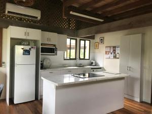 a kitchen with white cabinets and a white refrigerator at Beach-Villa 4 in South Mission Beach