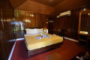 a bedroom with a large bed in a wooden room at Bluewater Beach Resort in Varkala