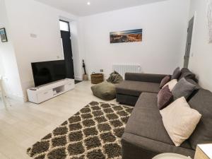 a living room with a couch and a flat screen tv at Arlanfor in Rhosneigr