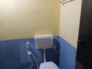 uma casa de banho com um WC numa parede azul em RV Homestay em Gokarna