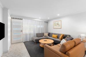 a living room with a couch and a table at City Courtyard One Apartment in Mount Gambier