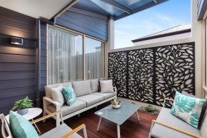 a balcony with a couch and a table at City Courtyard One Apartment in Mount Gambier