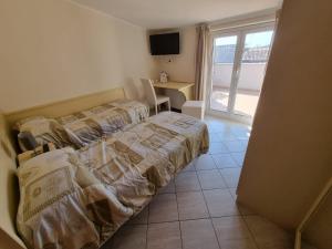 sypialnia z 2 łóżkami, biurkiem i oknem w obiekcie B&B e Casa Vacanza al Castello w mieście Roccella Ionica
