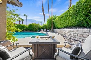 a patio with a table and chairs next to a swimming pool at California Dreamin' in Palm Springs