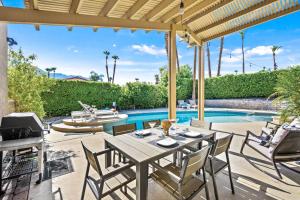 a patio with a table and chairs and a swimming pool at California Dreamin' in Palm Springs