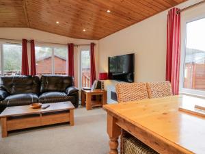 ein Wohnzimmer mit Ledermöbeln und einem Tisch in der Unterkunft Striding Edge Lodge in Windermere