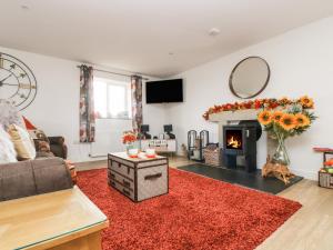 a living room with a fireplace and a red rug at Bear Cottage in Truro
