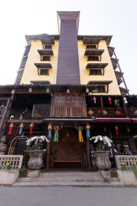 un bâtiment avec un front de magasin avec des drapeaux sur lui dans l'établissement Night Bazaar Inn, à Chiang Mai