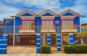 a blue and pink house with yellow and red doors at happiness house/ casa da felicidade in Cuiabá