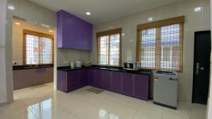 a kitchen with purple cabinets and a refrigerator at Simfoni Families Suite in Kuah