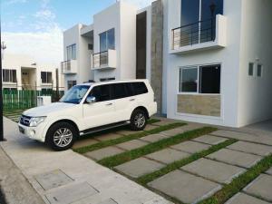 een witte SUV geparkeerd voor een gebouw bij Maravilloso apartamento en privada con alberca in Valente Díaz y La Loma