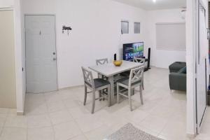 ein Esszimmer mit einem Tisch, Stühlen und einem Sofa in der Unterkunft Maravilloso apartamento en privada con alberca in Valente Díaz y La Loma